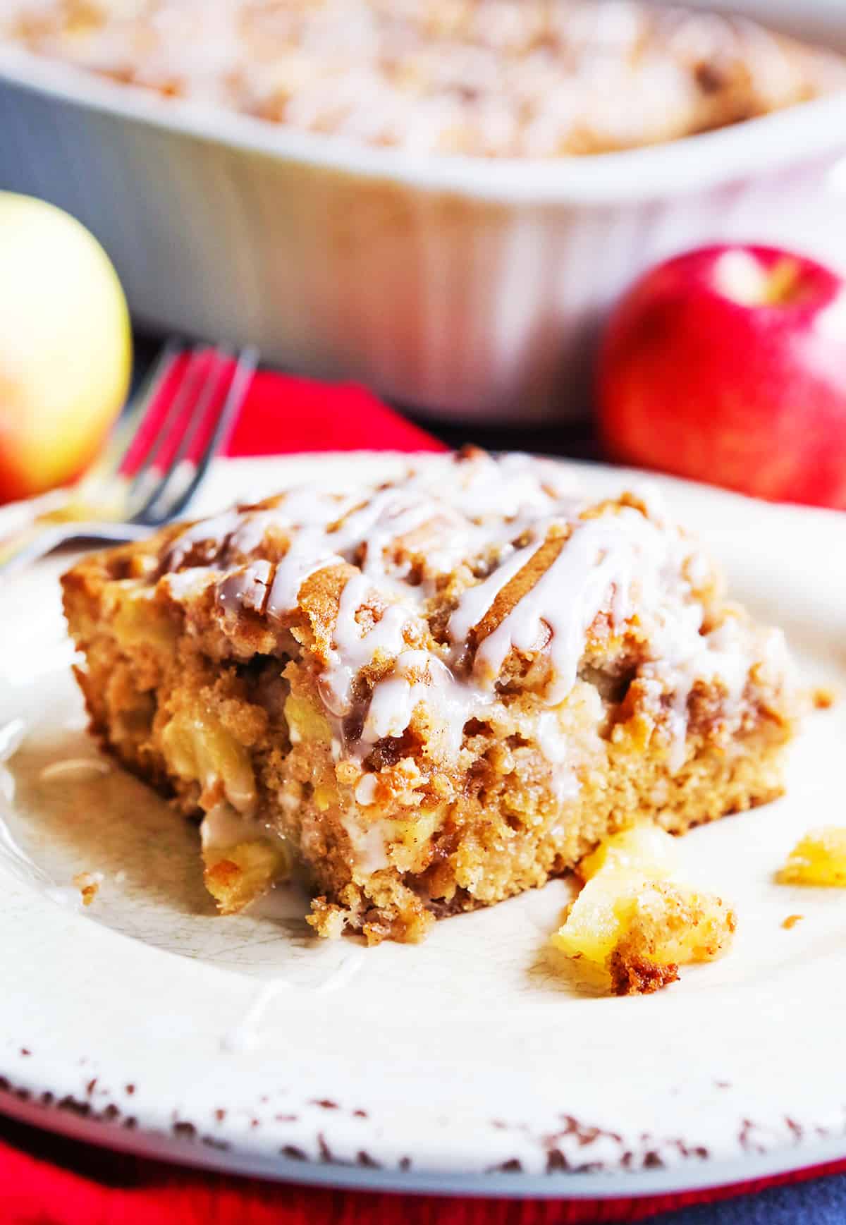 Slice of apple coffee cake drizzled with icing.