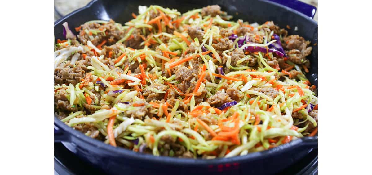 Egg roll coleslaw mixture in a skillet cooking.