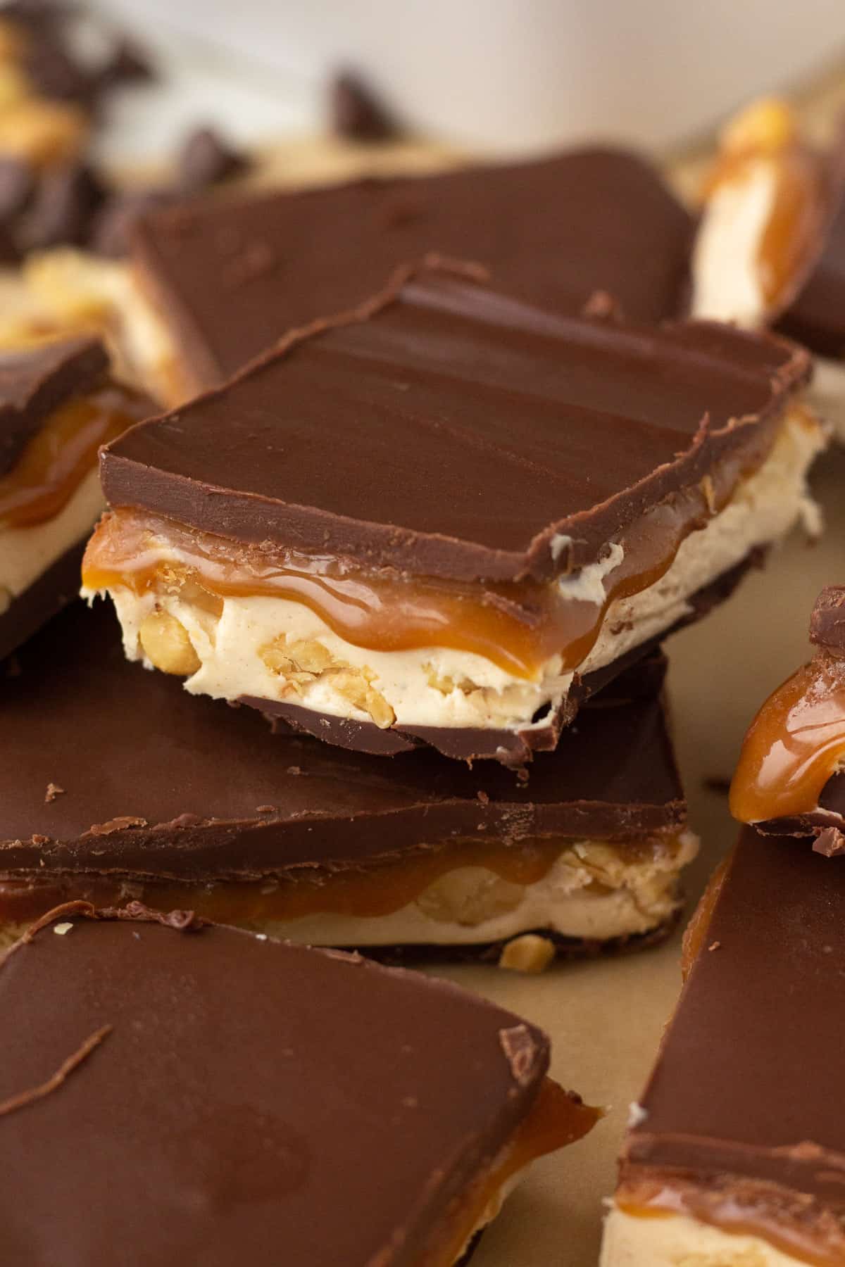 Stacked pieces of fudge with caramel dripping down sides.