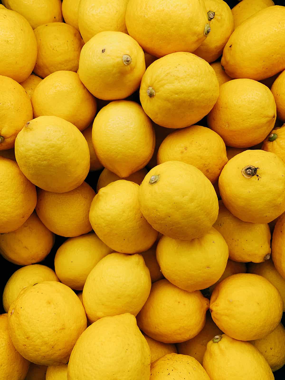 Dozens of lemons stacked together.
