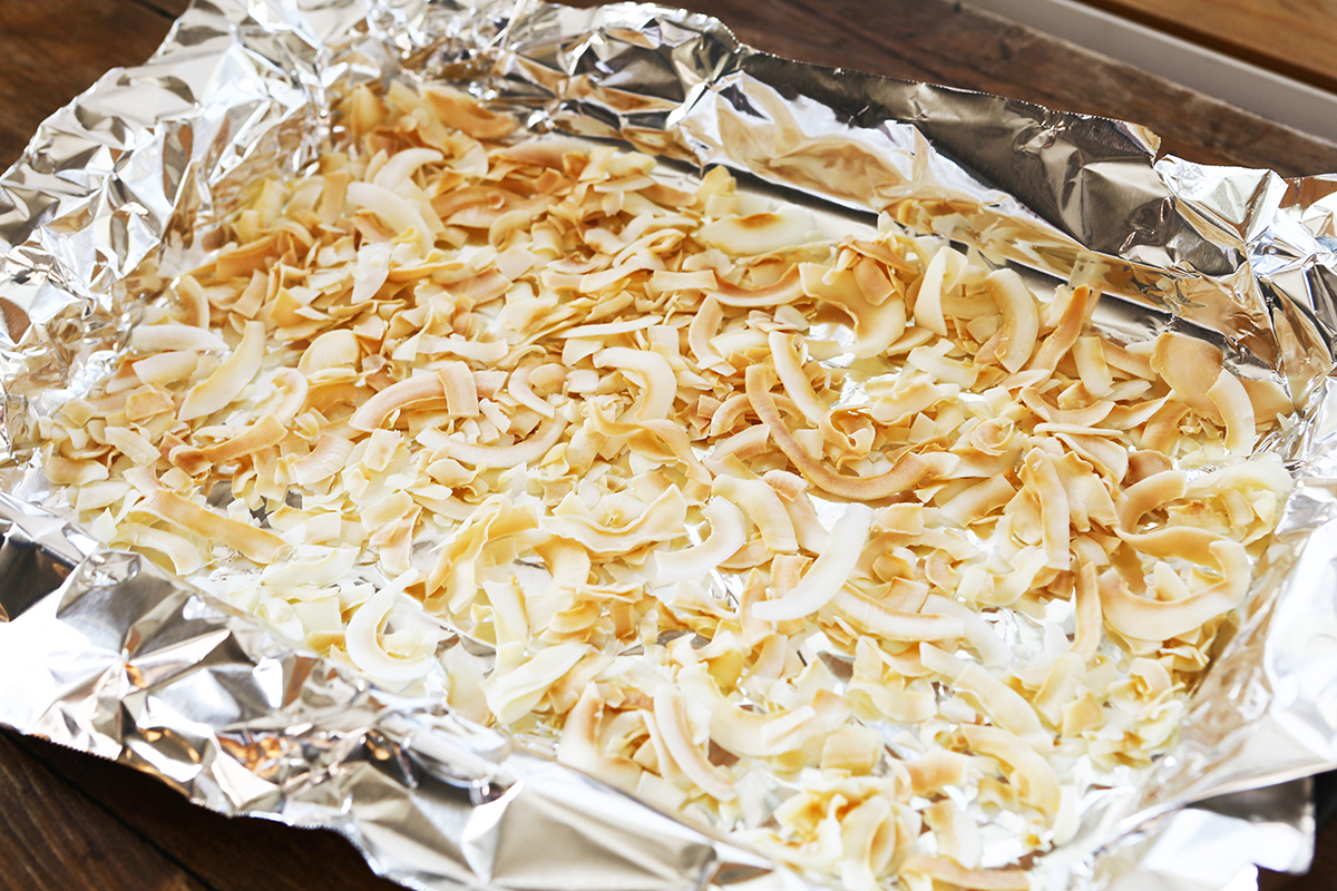 Foil lined baking sheet with shaved coconut on top.