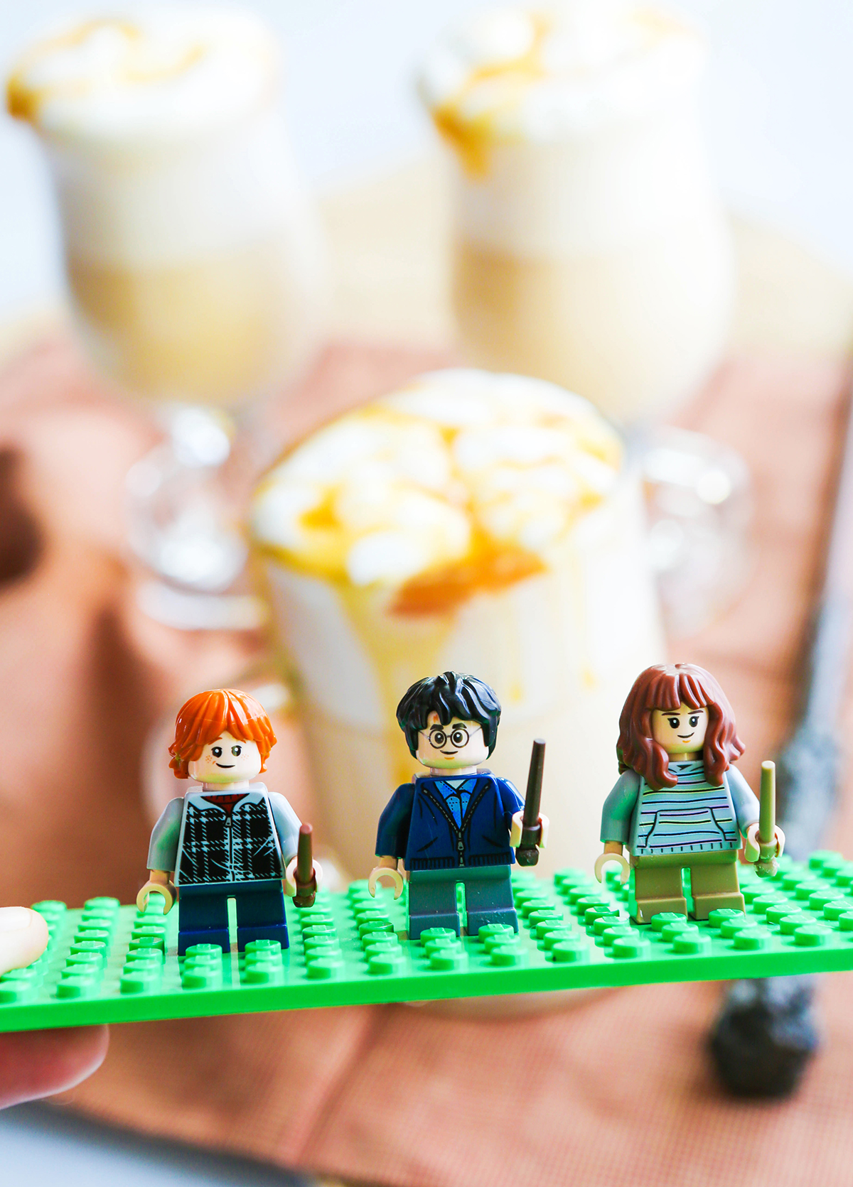 Lego Harry Potter characters standing in front of a few mugs of butterbeer.