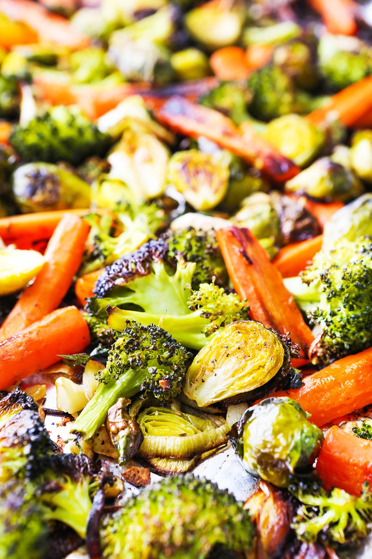 Close up of roasted veggies - brussels sprouts and broccoli and carrots.