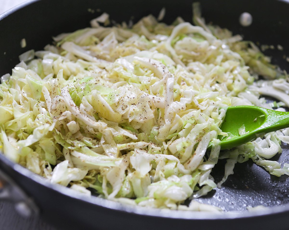 Sauteed cabbage with pepper in skillet.