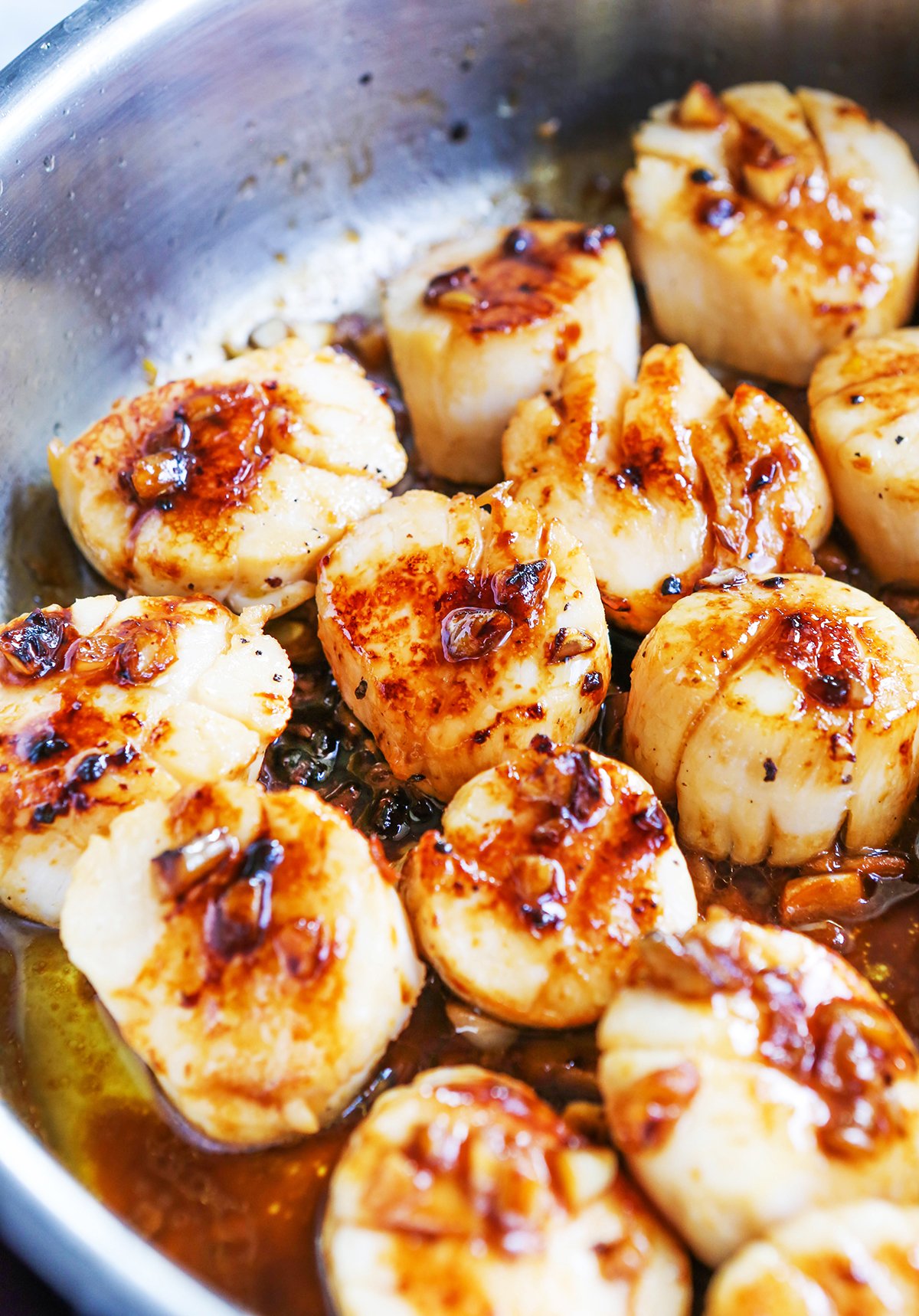 Close up of seared scallops in a skillet.