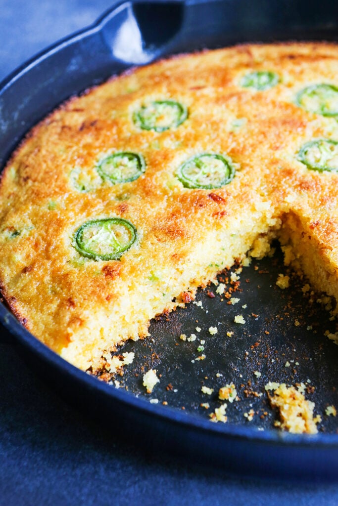 Baked cornbread made without buttermilk and jalapeno rounds in a cast iron skillet. 