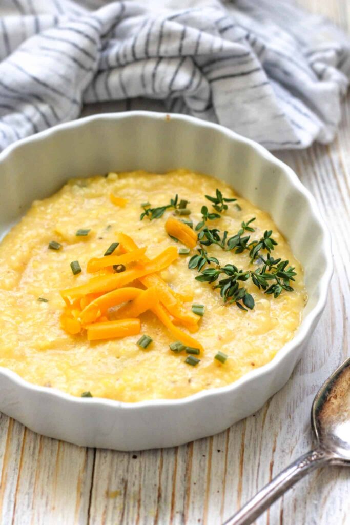 Container of polenta with some shredded cheese garnished on top. 