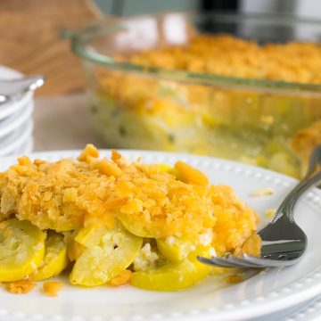 A serving of squash casserole with ritz crackers on a plate. 