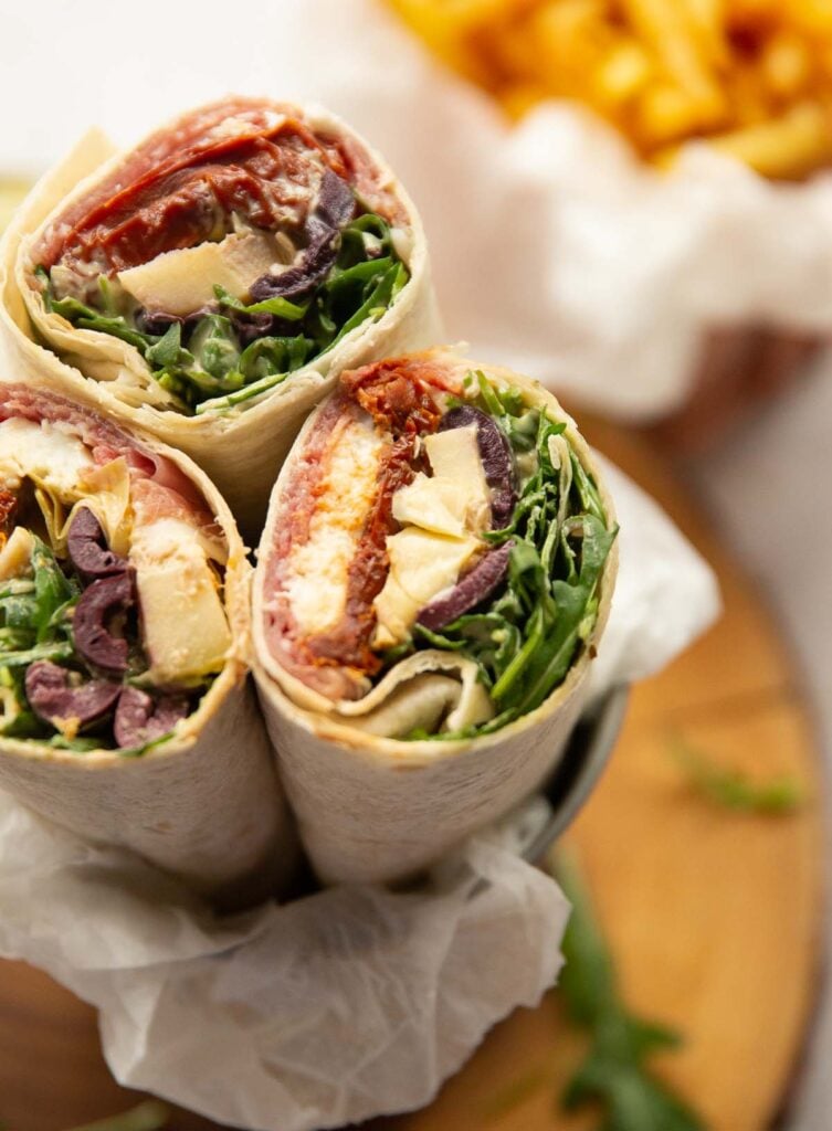 Three antipasto wraps showing the colorful ingredients inside. 