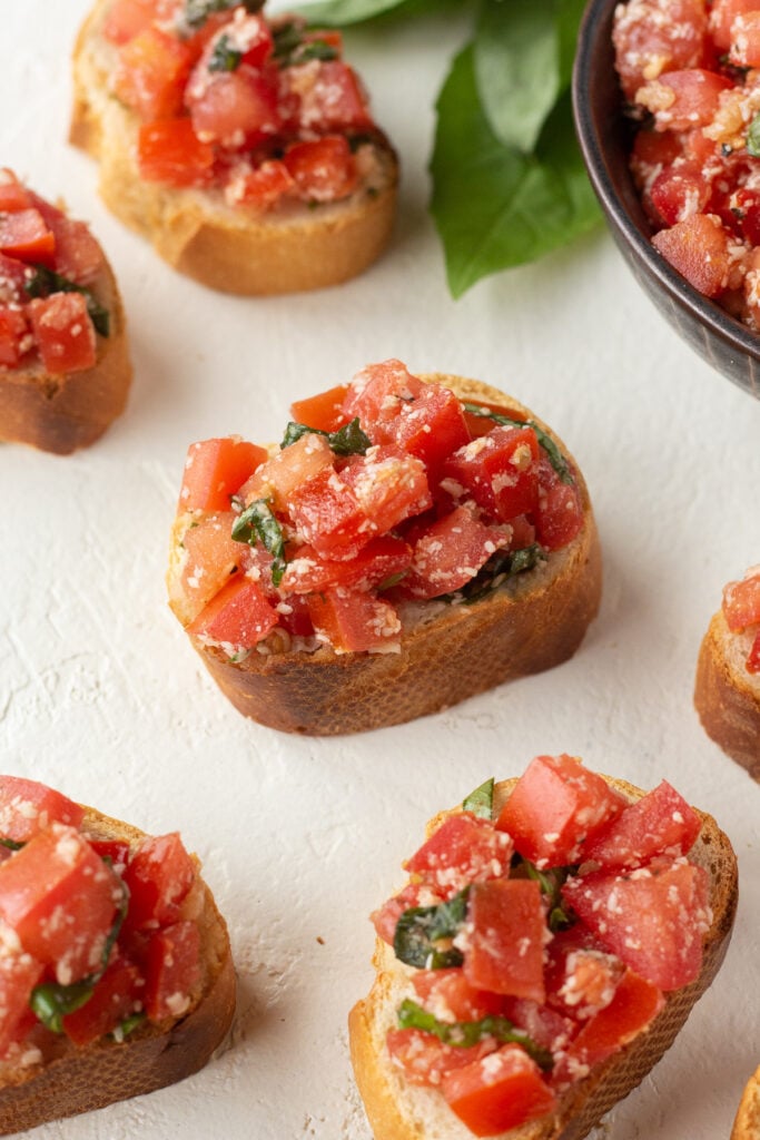 Bruschetta pieces lined up on a counter.