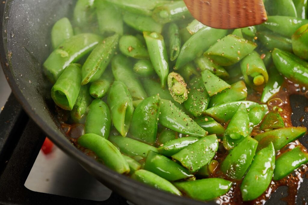 Pan of soy glazed sugar snap peas. 