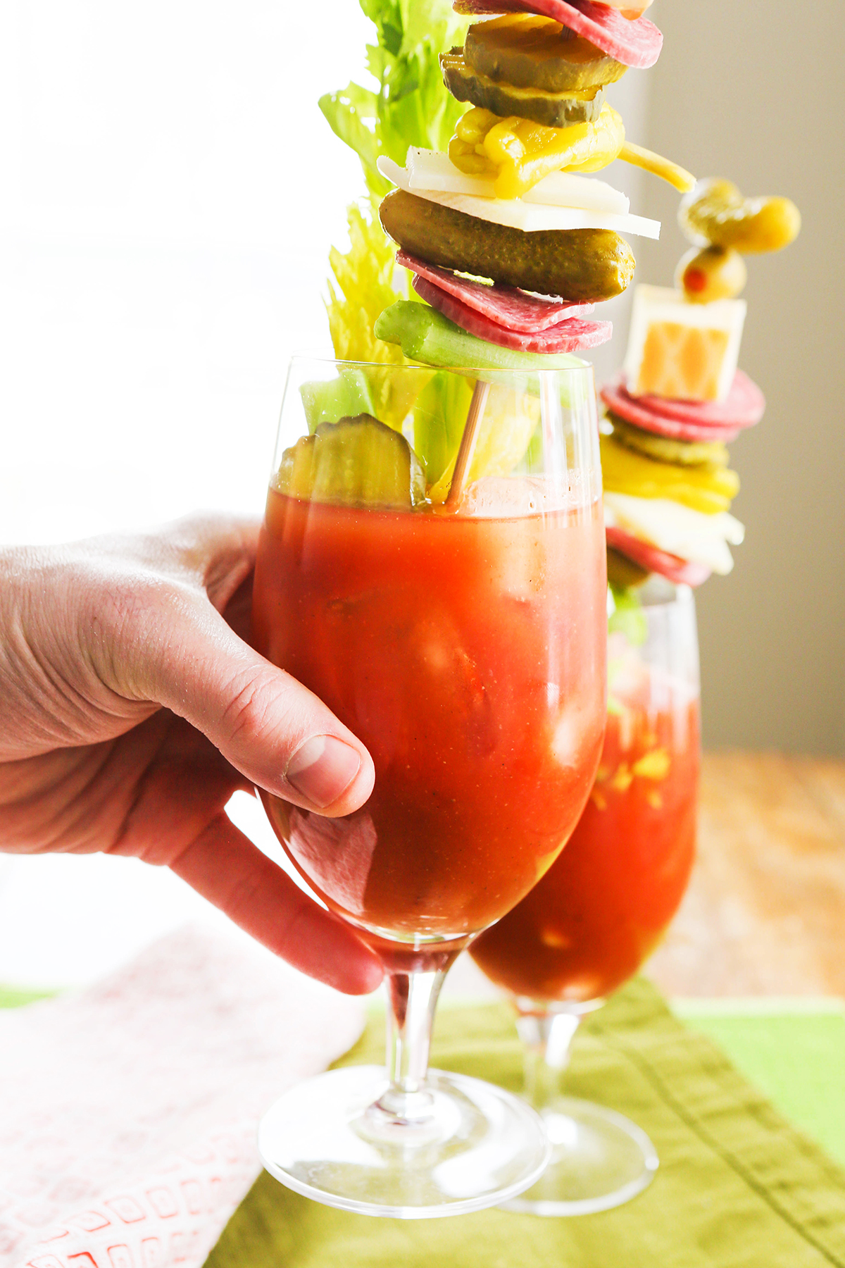 Hand holding a loaded bloody mary cocktail.