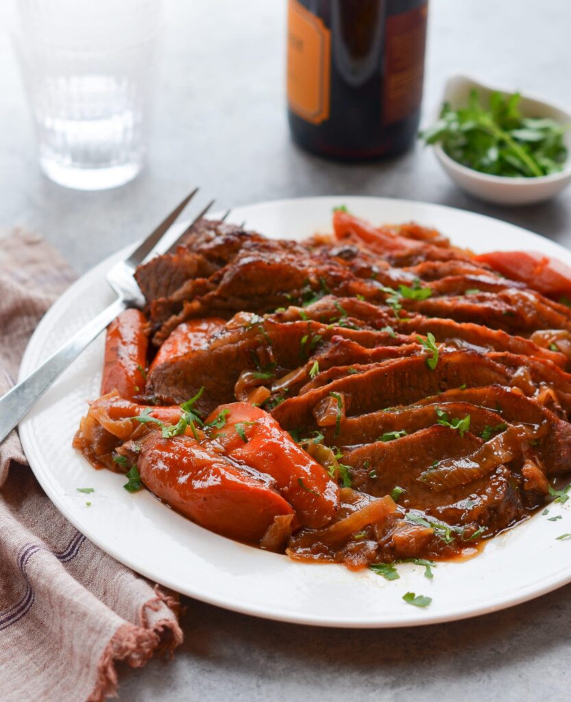 Onion braised beef brisket on a serving plate. 