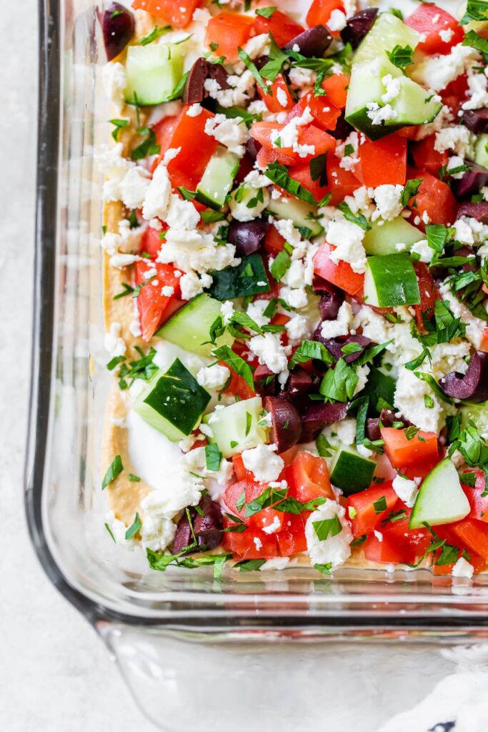 Greek layer dip in a glass dish. 