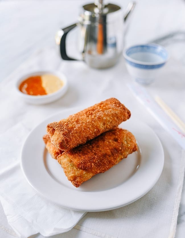 3 eggrolls stacked on a plate. 