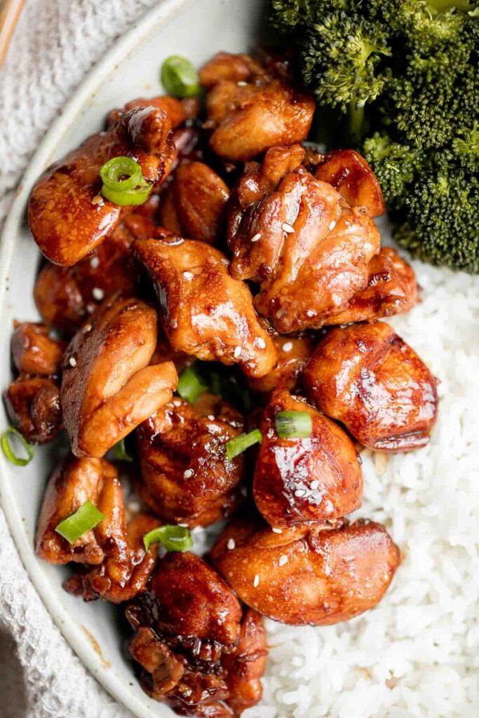 Teriyaki chicken served alongside broccoli and rice. 