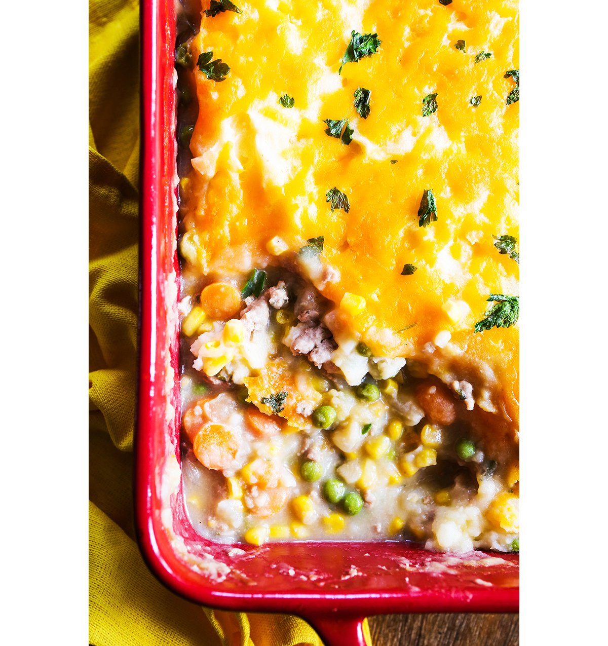 Top view of a casserole dish filled with cheese-topped shepherd's pie.