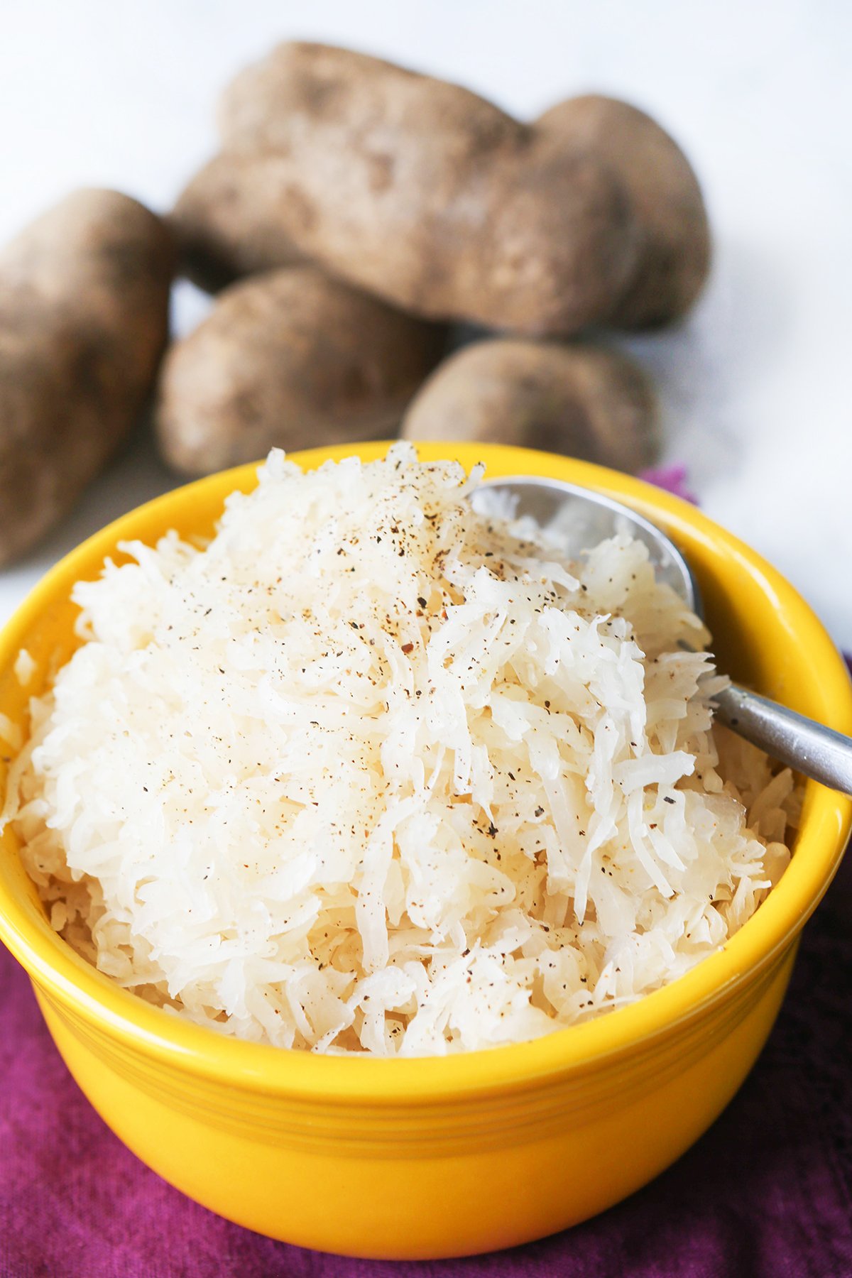Bowl of sauerkraut with a serving spoon inside.
