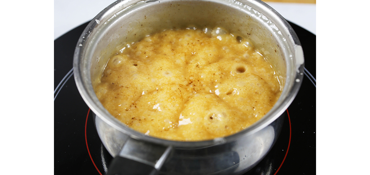 Boiling caramel sauce in a saucepan.