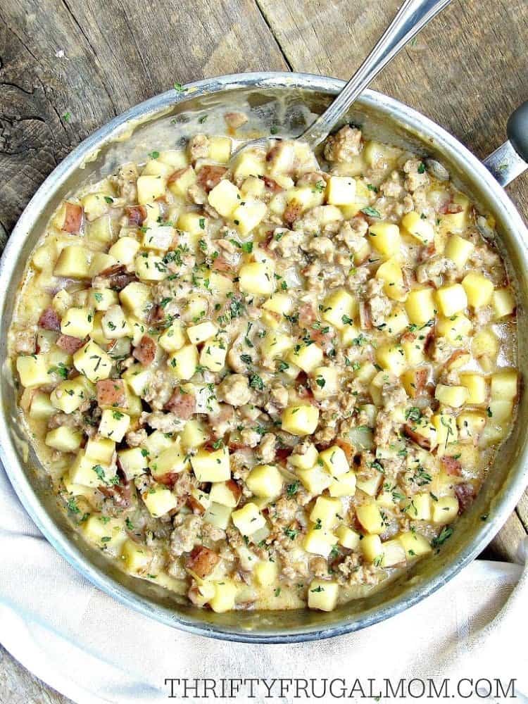 Top view of a skillet topped with potatoes and sausage. 