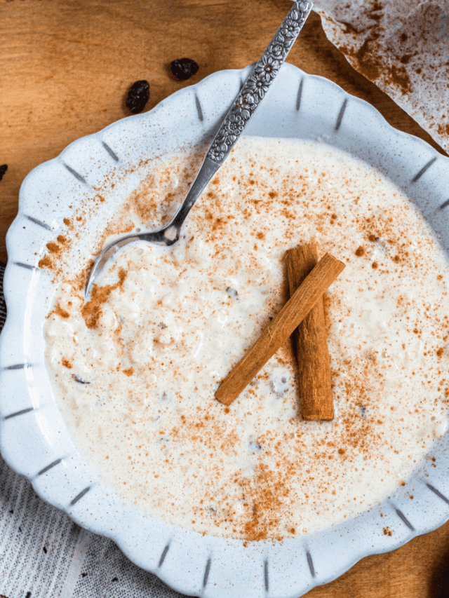 Arroz con leche in a bowl with 2 whole cinnamon sticks. 