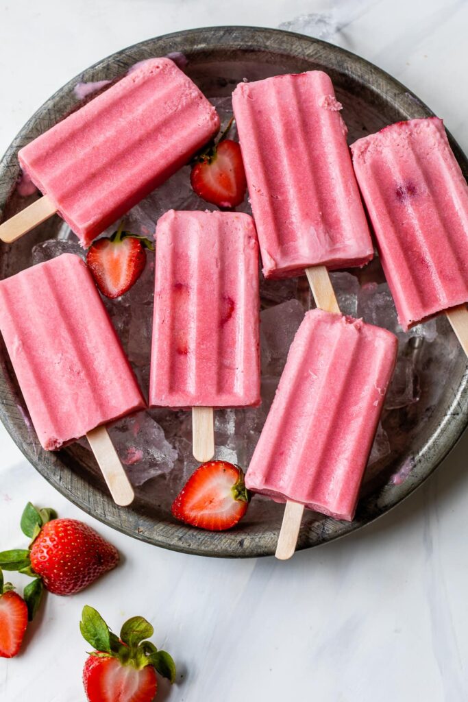 Paletas de fresa on a bowl with ice cubes under it. 