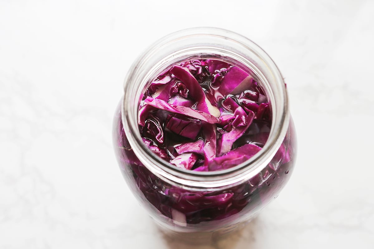 Top view of red cabbage in a jar with water.