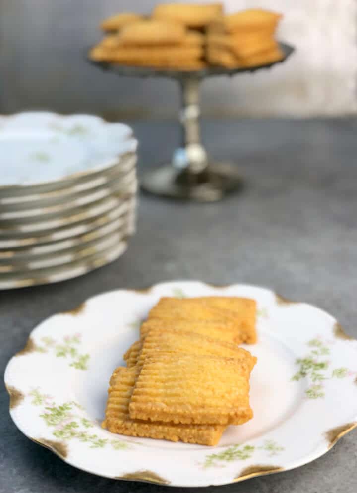 Cheese straw crackers on a small decorative plate. 