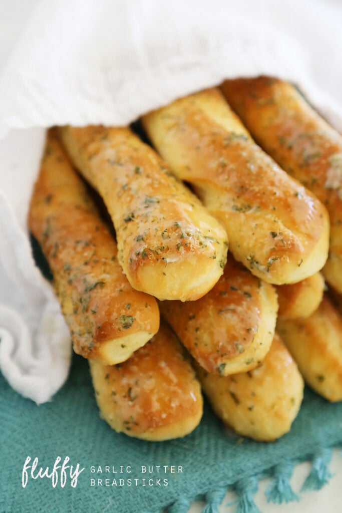 Garlic butter breadsticks wrapped in a towel. 