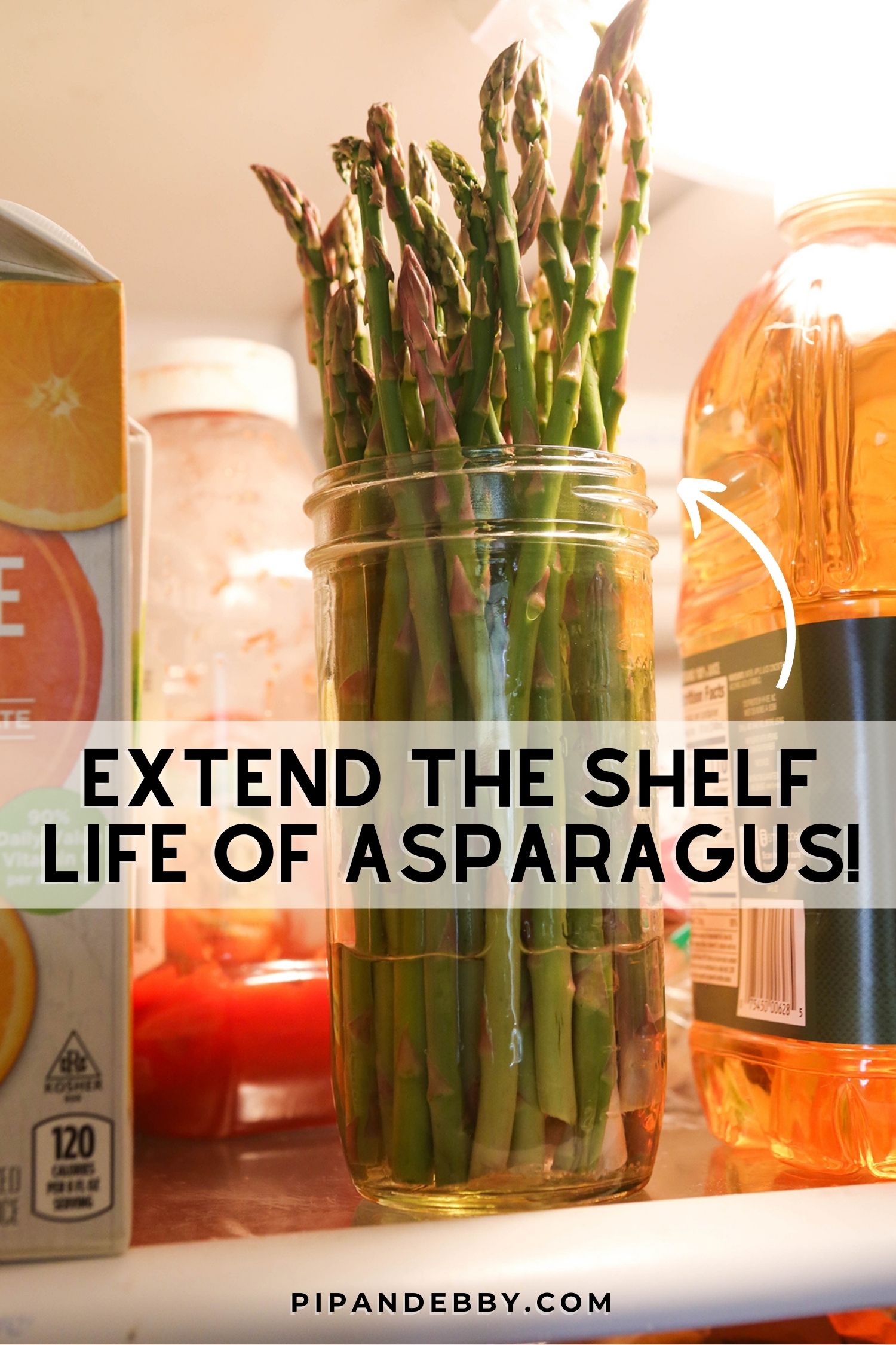 Asparagus spears in a jar with water sitting in the fridge with text overlay: "Extend the shelf life of asparagus!"