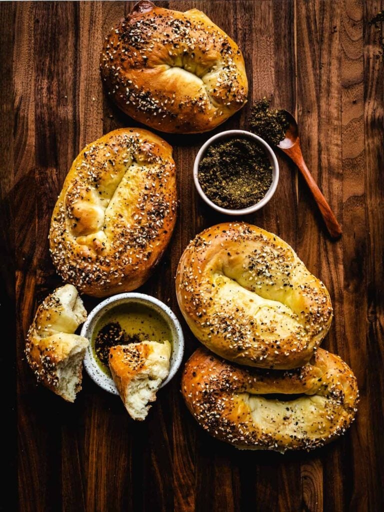 Jerusalem bagels with seasoning on it and some seasoned olive oil in a small bowl. 