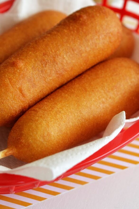 Homemade corn dogs sitting in a basket. 