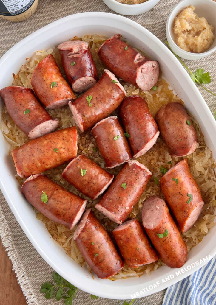 Kielbasa cut into large chunks and placed over sauerkraut in a casserole dish. 