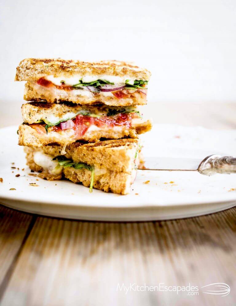 Grilled Italian vegetarian panini cut in half and stacked on top of one another. 