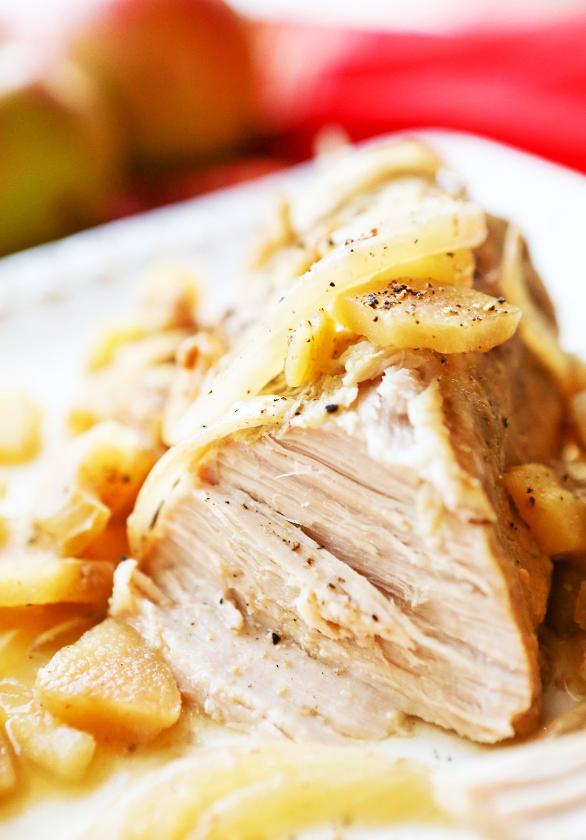 Inside of a pork loin with tender meat and topped with onions and apples.