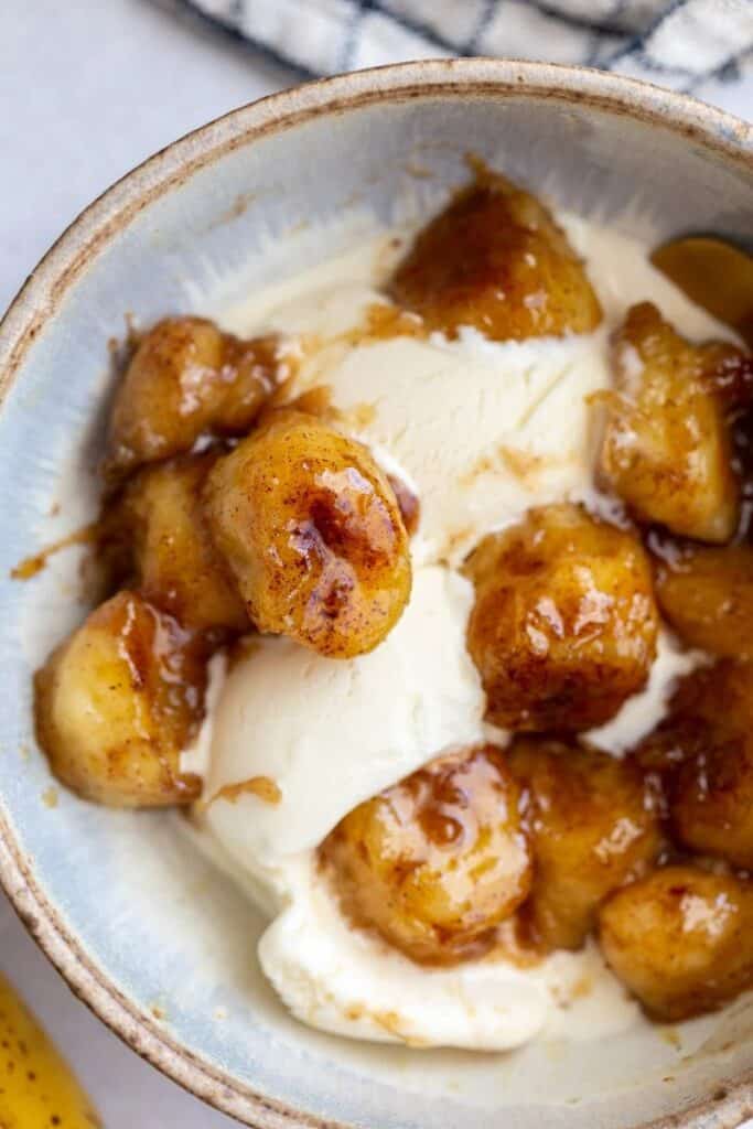 Caramelized bananas over vanilla ice cream in a bowl. 