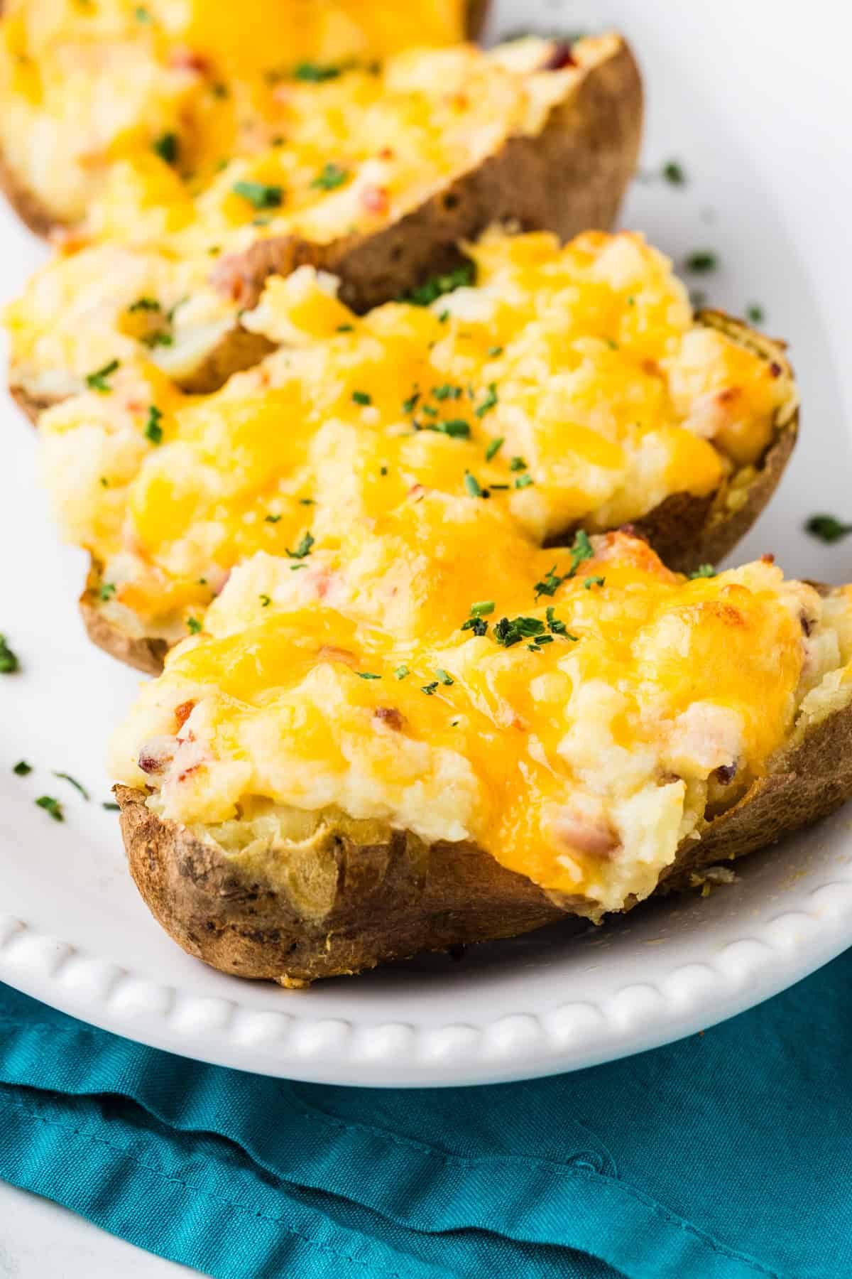 Serving platter lined with cheesy baked potato halves.