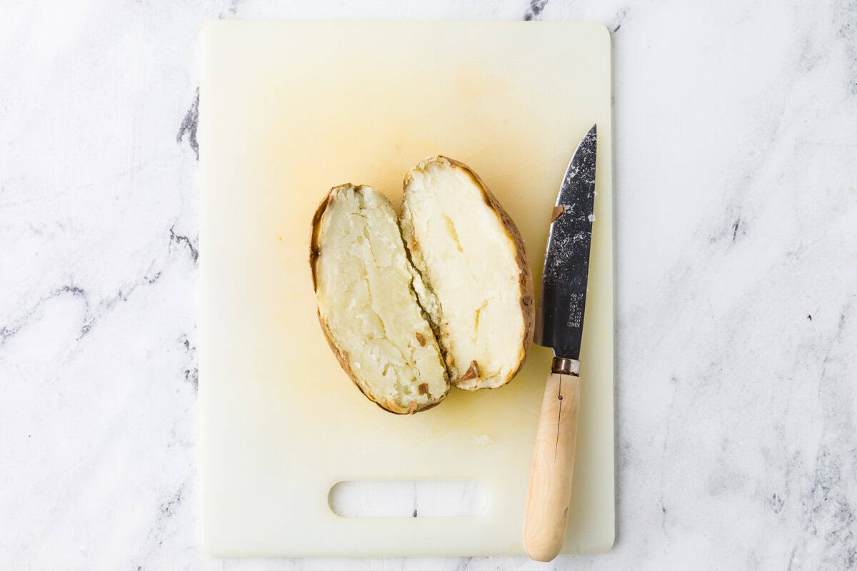 A baked potato cut in half lengthwise.