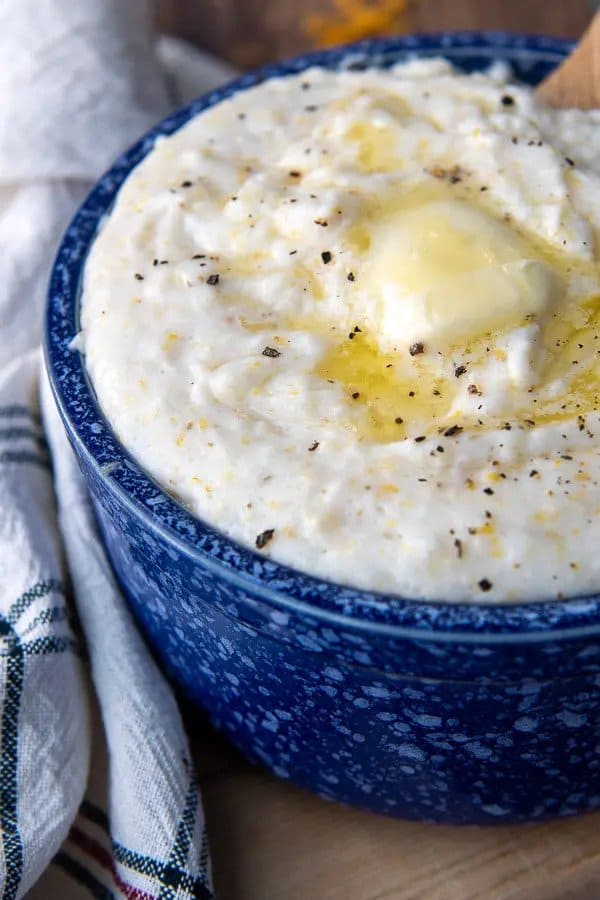 Serving bowl of grits with a pat of butter melting over it. 