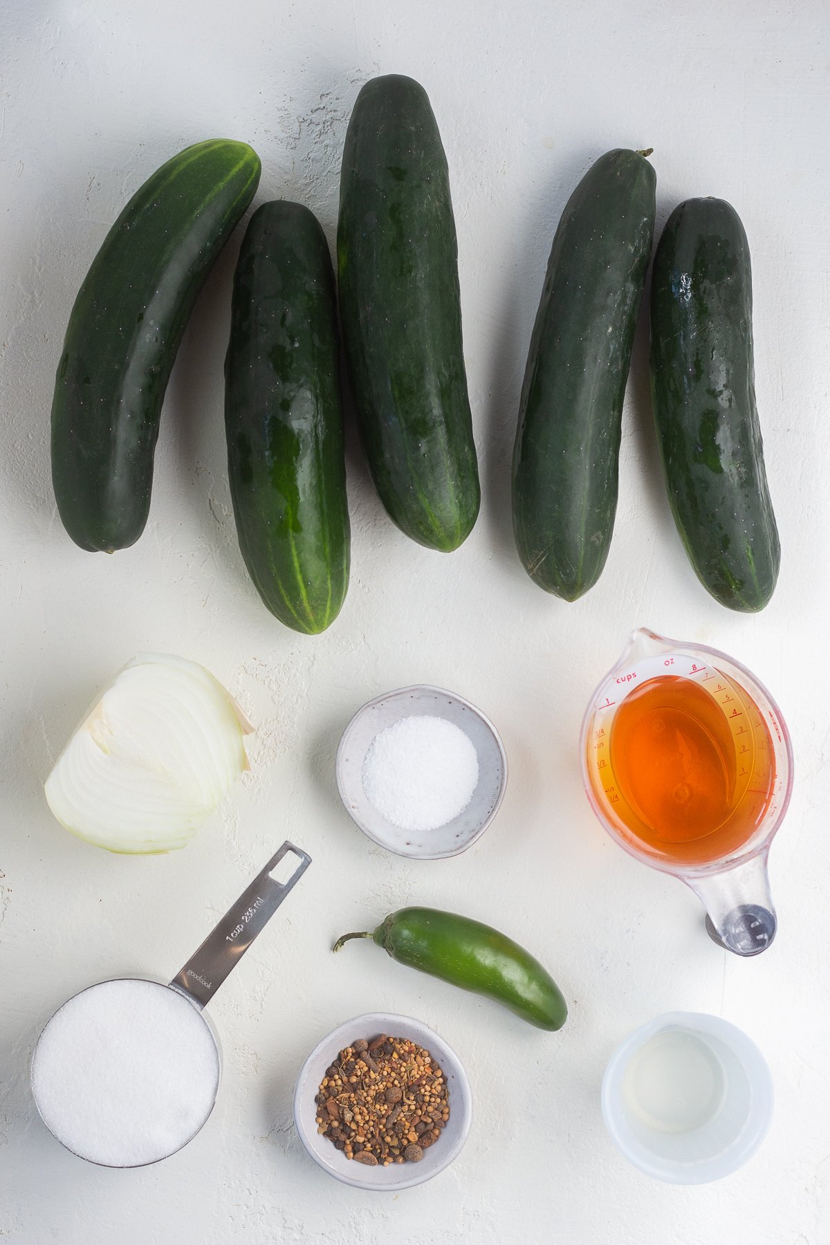 Ingredients for homemade pickles lined up on a counter.