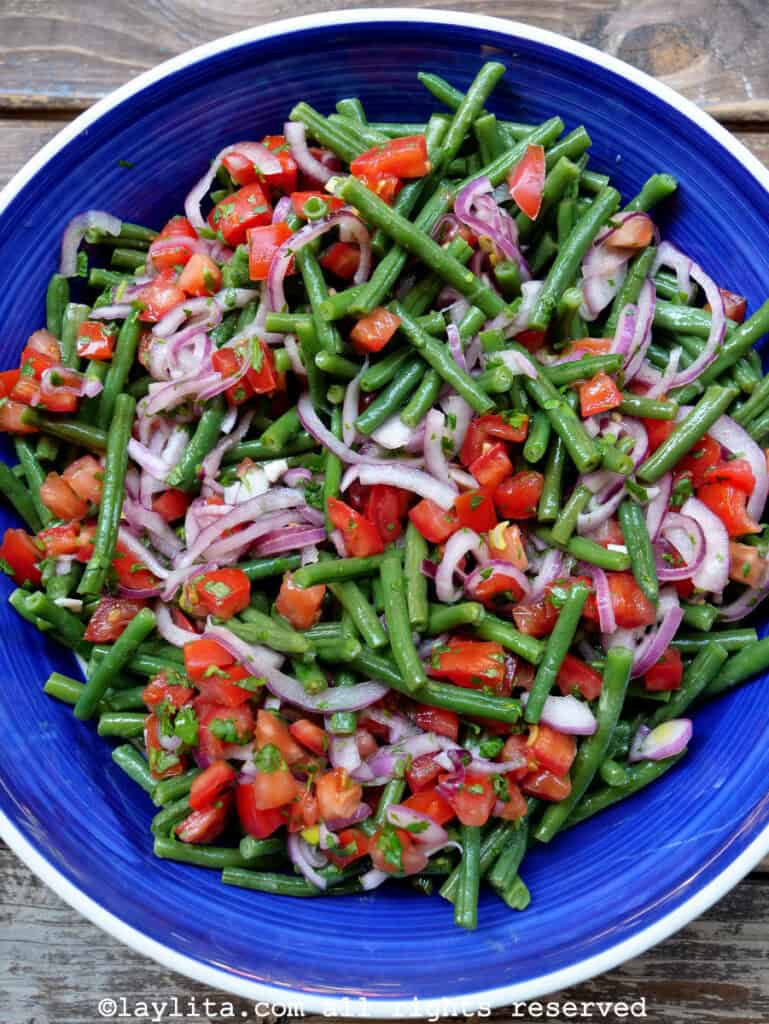 Green bean tomato salad served in a blue salad bowl. 