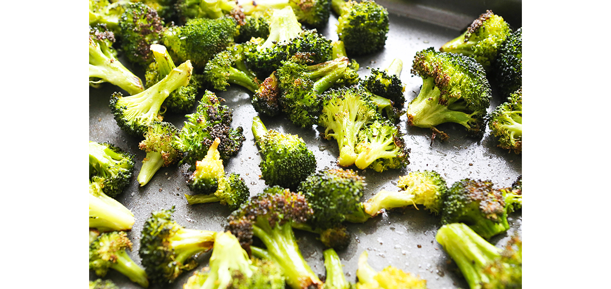 Crispy roasted broccoli florets on a baking sheet.