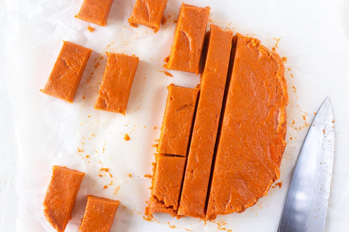 Homemade Butterfingers candy cut into pieces on parchment paper.