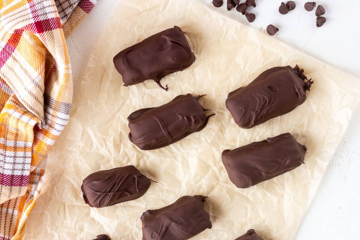 Homemade chocolate-covered Butterfingers on parchment paper.
