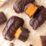 Chocolate-covered homemade Butterfingers with orange filling on parchment paper.