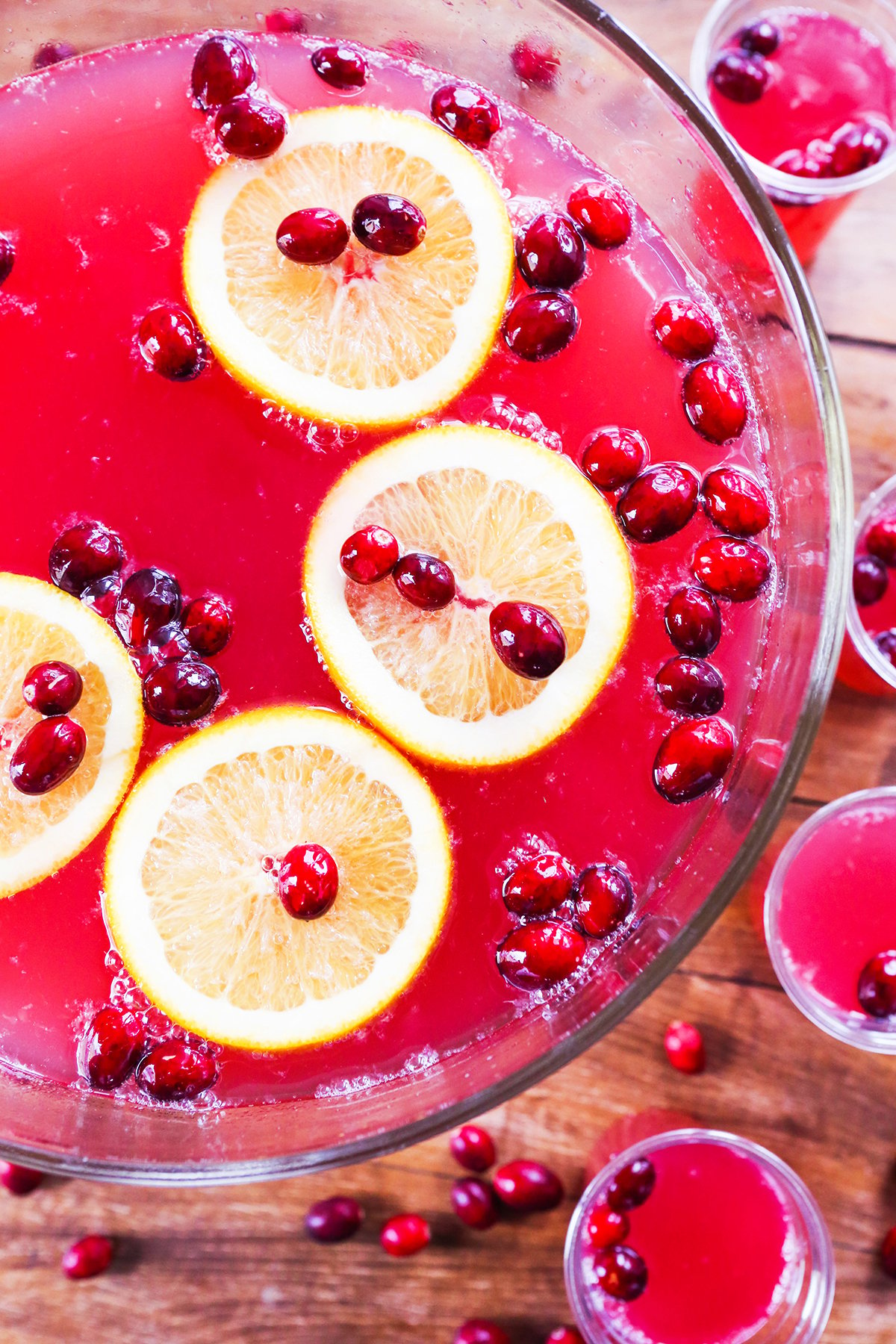 Beautiful punch bowl filled with red punch and topped with cranberries and oranges.