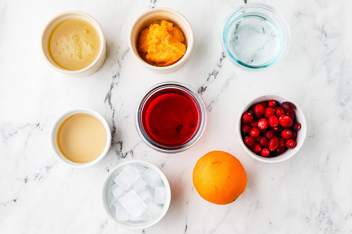 Ingredients for cranberry ginger ale punch lined up on a counter.