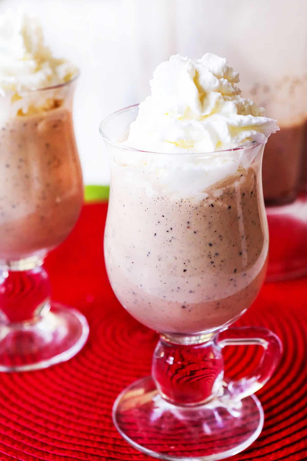 Two glasses filled with baileys and whipped cream, sitting side by side.