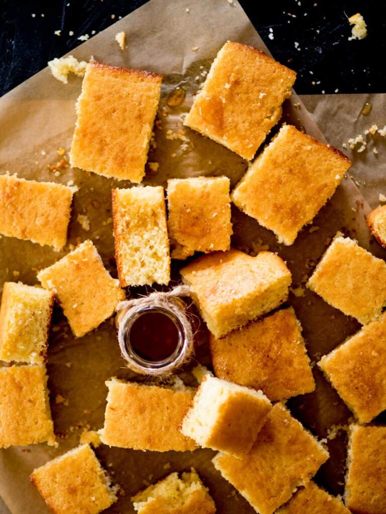 Square pieces of cornbread on parchment paper. 