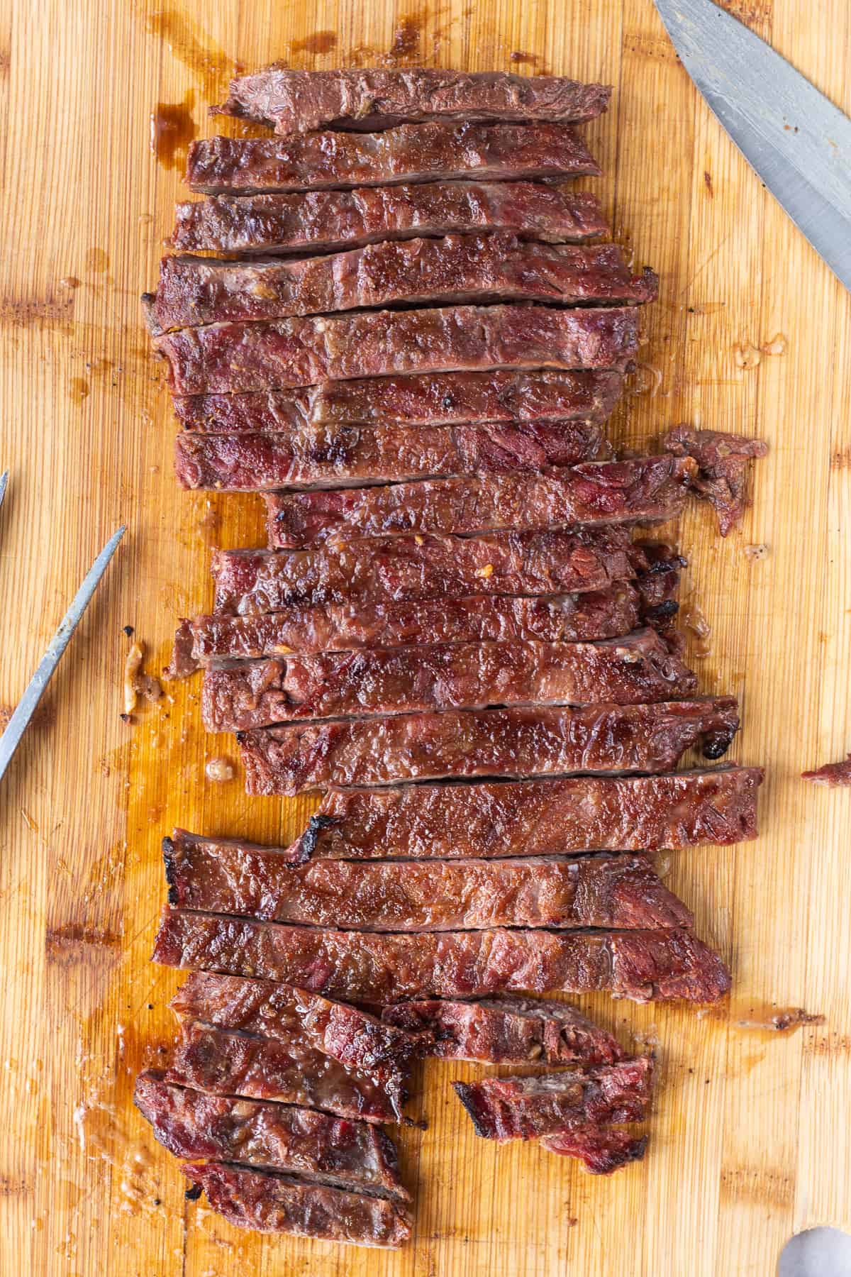 Skirt steak prepared on the Traeger on a cutting board and sliced into pieces. 